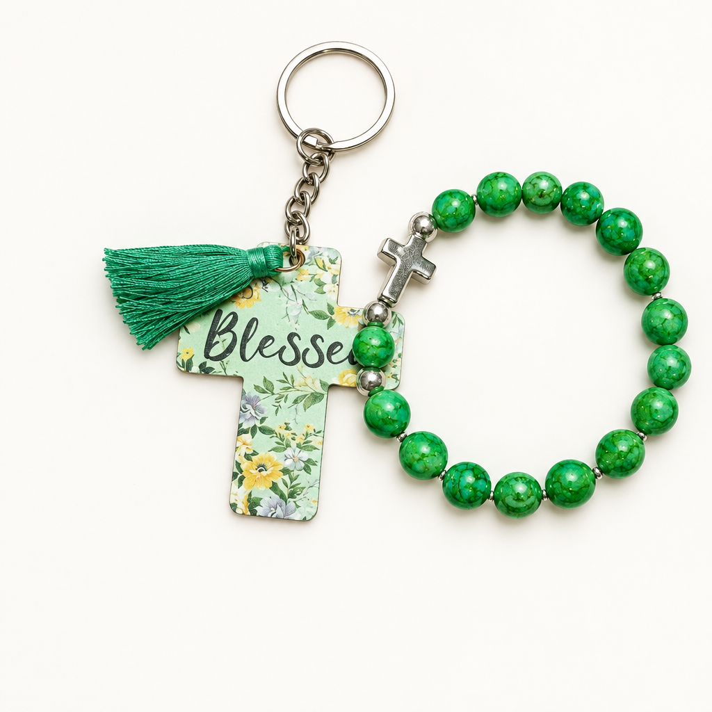 Marbled green beaded stretch bracelet with silver cross charm beside a mint green cross tag keychain with florals, Blessed lettering, and green tassel