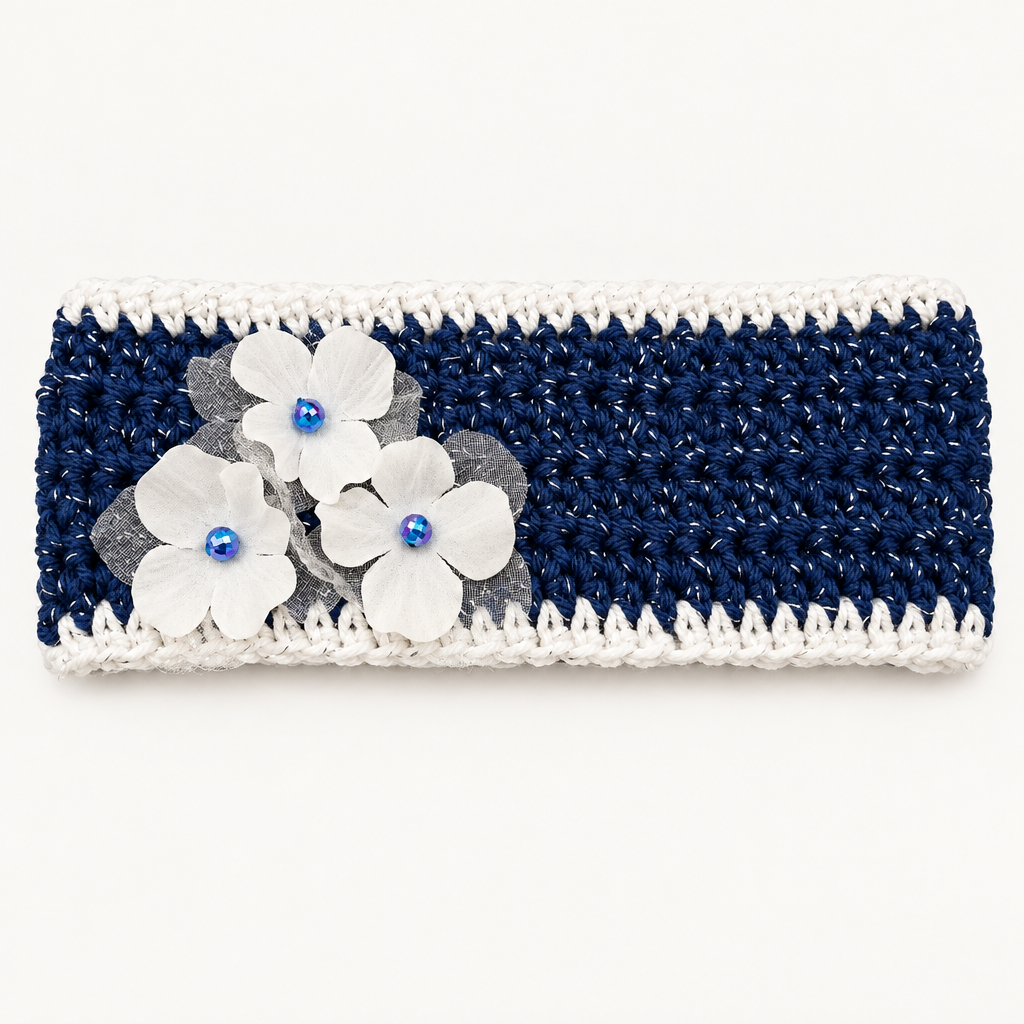 Handmade crocheted headband in navy blue with silver sparkle, ruffled white trim, and white fabric flowers with blue gem centers