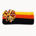 Handmade crocheted Candy Corn Halloween headband in black, orange, yellow, and white stripes with a loopy crochet flower and candy corn button